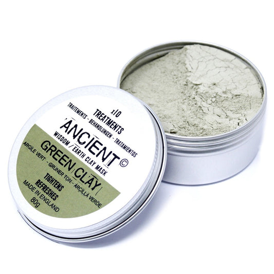 A tin of Ancient Green Clay is partially opened, revealing its light-grey, powdery contents. The label indicates it’s a face mask that tightens and refreshes, made in England.