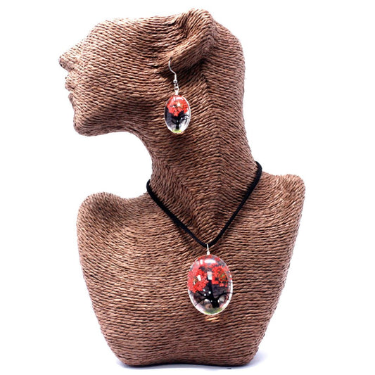 A jewelry set, including a necklace and earrings with red, black, and green in oval pendants, is displayed on a brown textured mannequin bust against a white background.