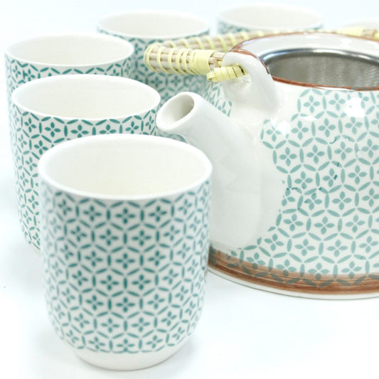 Ceramic teapot with a bamboo handle and six matching cups, all featuring a teal geometric pattern, set against a white background.