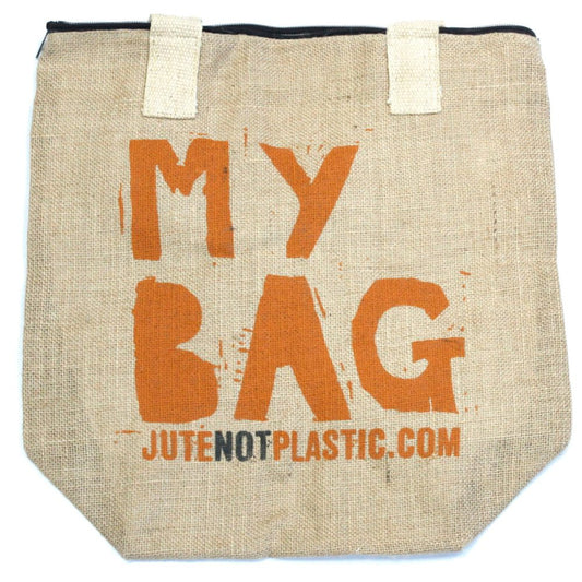 A tan tote bag rests on a white surface. The bag says "MY BAG JUTENOTPLASTIC.COM" in orange block letters. It has two white fabric handles, a zipper, and a slightly tapered shape.
