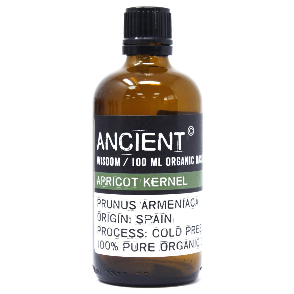 A brown glass bottle sits on a white background. The bottle is labeled "ANCIENT WISDOM / 100 ML ORGANIC BASE APRICOT KERNEL PRUNUS ARMENIACA ORIGIN: SPAIN PROCESS: COLD PRESSED 100% PURE ORGANIC."