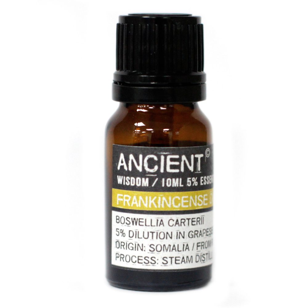 A brown glass vial, capped with a black lid, is centered in front of a white background. The label reads "ANCIENT, WISDOM/10ML 5% ESSEN, FRANKINCENSE, BOSWELLIA CARTERII, 5% DILUTION IN GRAPESEED, ORIGIN: SOMALIA / FROM, PROCESS: STEAM DISTIL".