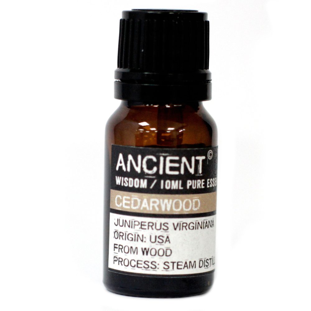 A brown glass bottle sits on a white surface; its label reads: "ANCIENT WISDOM / 10ML PURE ESSE CEDARWOOD JUNIPERUS VIRGINIANA ORIGIN: USA FROM WOOD PROCESS: STEAM DISTIL."