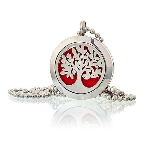 A round, silver necklace features a tree cutout exposing a red pad. The necklace is on a beaded chain and is set against a white backdrop.