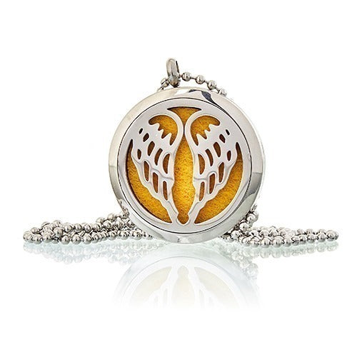 A silver, round pendant with carved wings holds a yellow felt pad, dangling from a beaded silver chain on a white surface.