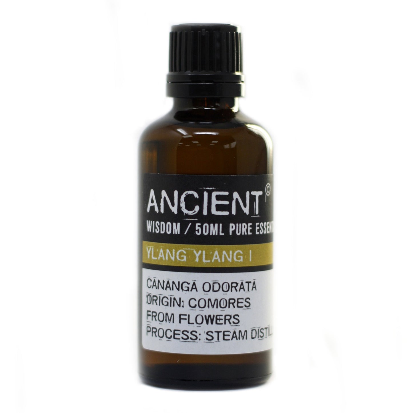 A dark brown bottle stands on a white surface, labeled "ANCIENT WISDOM / 50ML PURE ESSEN, YLANG YLANG I, CANANGA ODORATA ORIGIN: COMORES, FROM FLOWERS PROCESS: STEAM DISTIL".