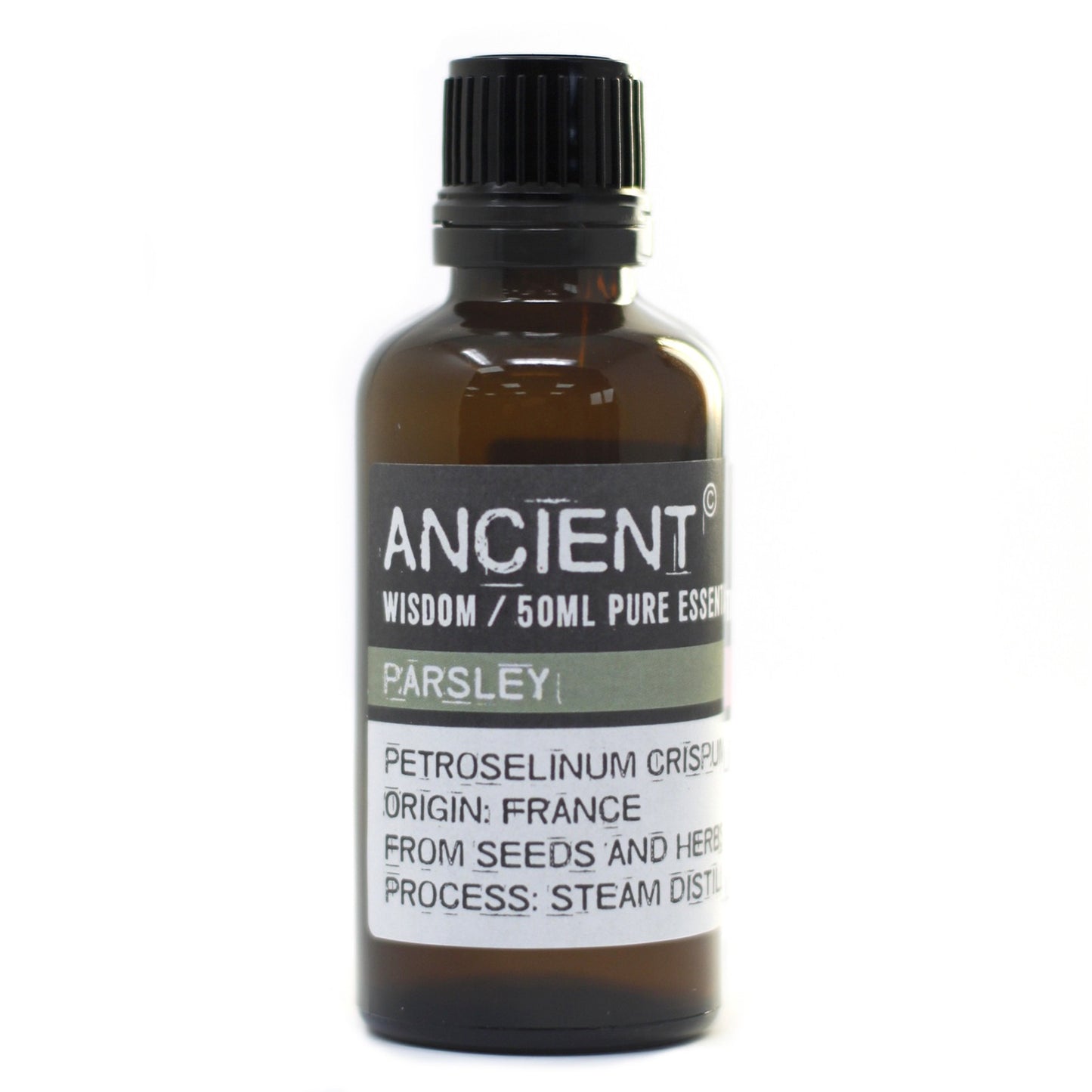 A brown glass bottle of "ANCIENT" brand Parsley essential oil sits on a white surface. The label reads: "ANCIENT, WISDOM / 50ML PURE ESSENT, PARSLEY, PETROSELINUM CRISPU, ORIGIN: FRANCE, FROM SEEDS AND HERB, PROCESS: STEAM DISTIL."