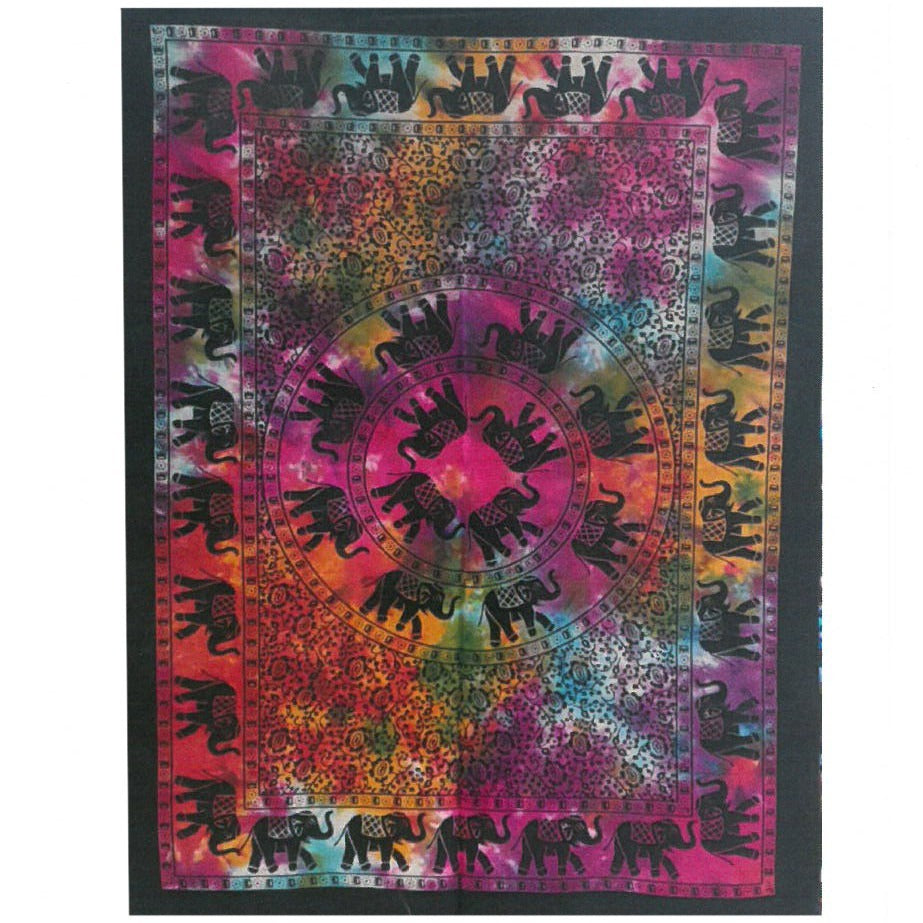 A tapestry displays black elephants on a tie-dye background of pink, orange, and teal. The elephants are arranged in concentric circles and along the border.