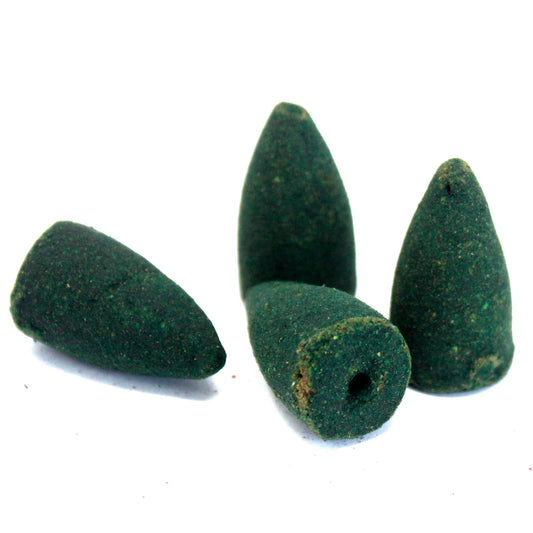 Four green incense cones rest on a white surface, with one cone lying horizontally and the others standing upright, featuring small holes at their bases.
