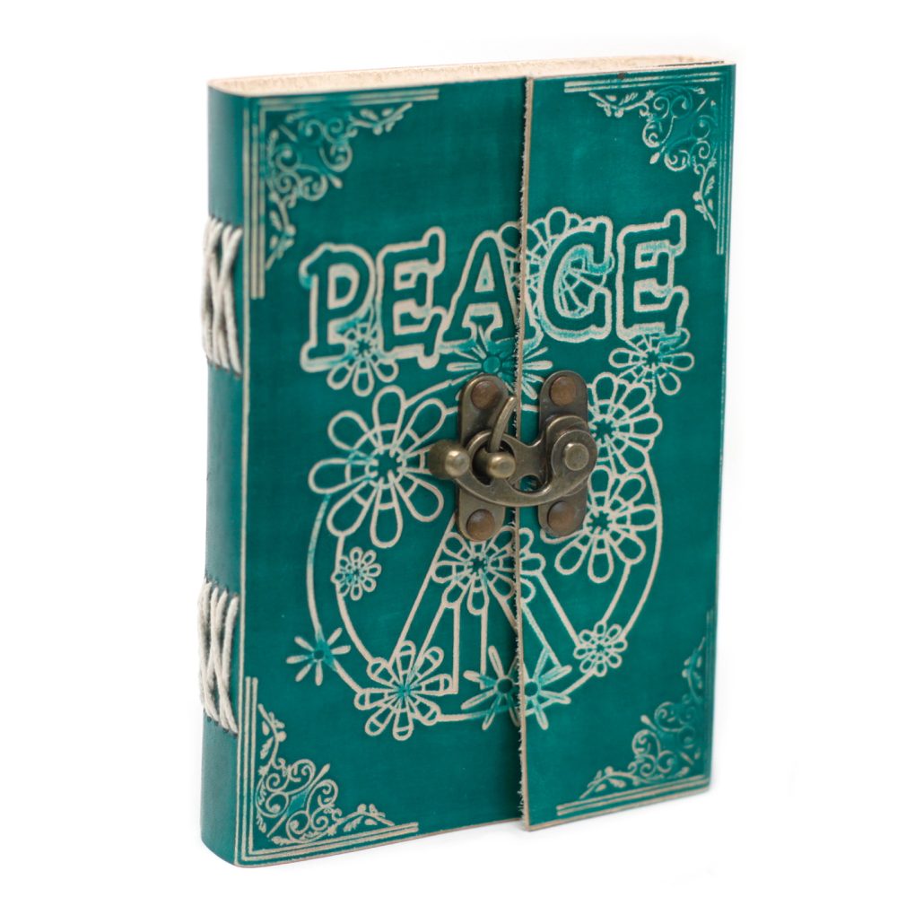 A turquoise-colored journal with a bronze clasp is closed, featuring the word "PEACE" and a white flower peace symbol on the cover, on a white surface.