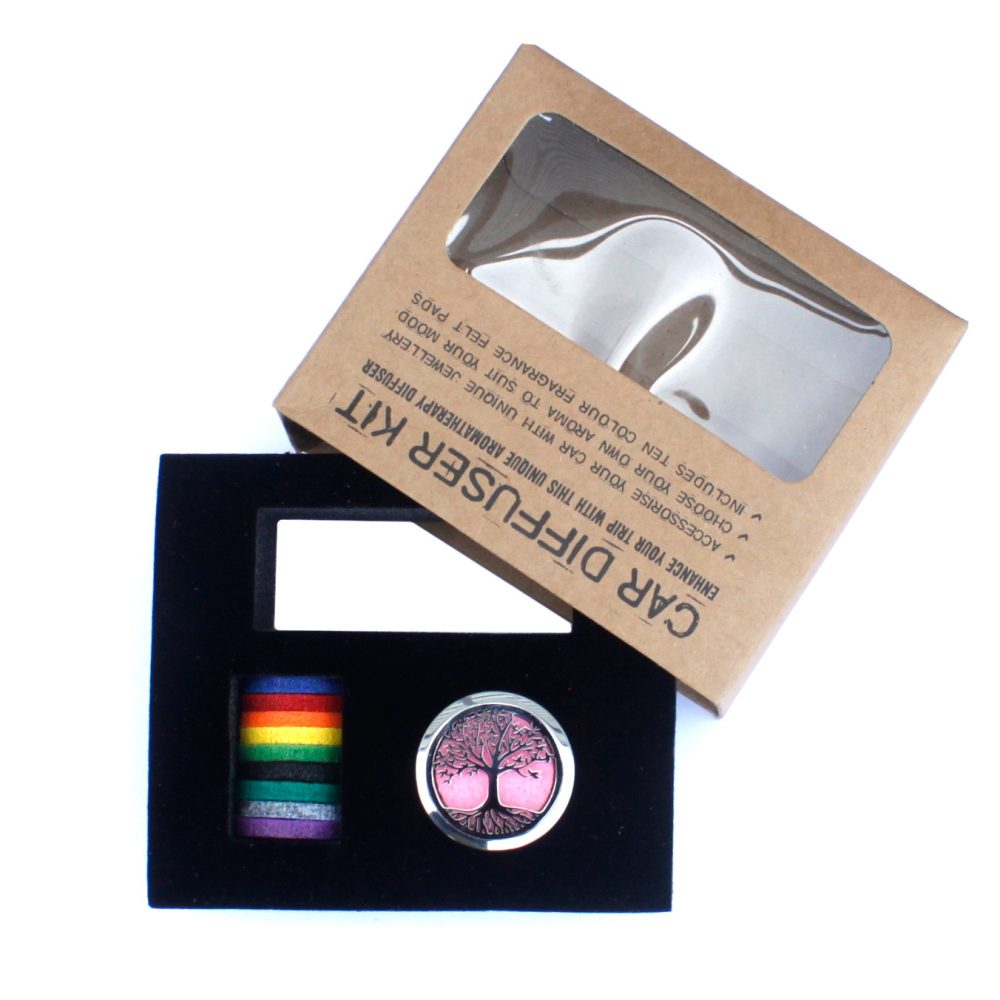 A car diffuser kit, reading "CAR DIFFUSER KIT, ENHANCE YOUR TRIP WITH THIS UNIQUE AROMATHERAPY DIFFUSER, ACCESSORISE YOUR CAR WITH UNIQUE JEWELLERY, CHOOSE YOUR OWN AROMA TO SUIT YOUR MOOD, INCLUDES TEN COLOUR FRAGRANCE FELT PADS", is presented in a black box alongside colorful felt pads on white.
