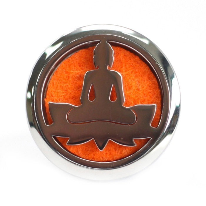 A metallic disk shows the silhouette of a person meditating on a lotus flower. The silhouette is against a fuzzy orange backing, all on a white background.