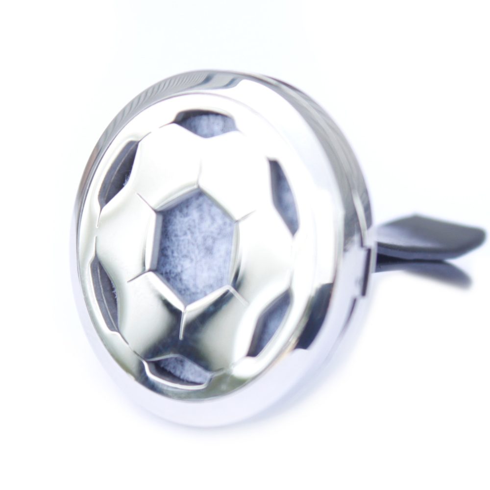 A shiny, spherical air freshener shaped like a soccer ball sits against a bright white background. The freshener has a dark vent clip attached.
