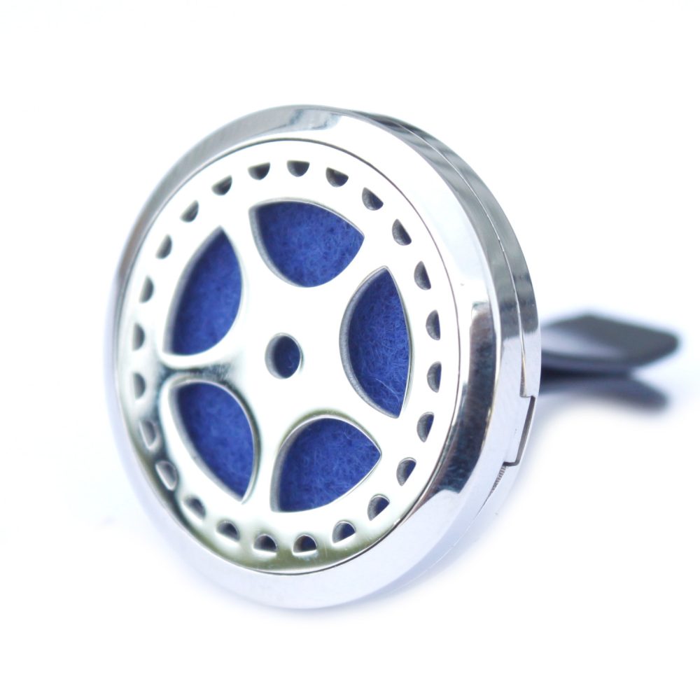 A chrome car air freshener shows a five spoke circle shape with blue felt filling the inner spaces, and is connected to a black clip. The backdrop is bright white.