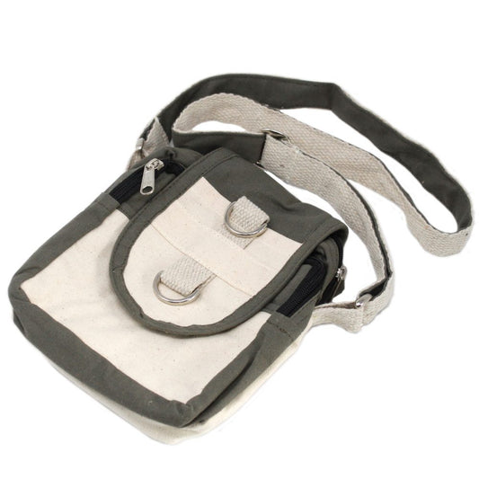 A cream and gray canvas satchel with a flap is strapped on a white surface. The satchel features silver hardware and a small zippered pouch.