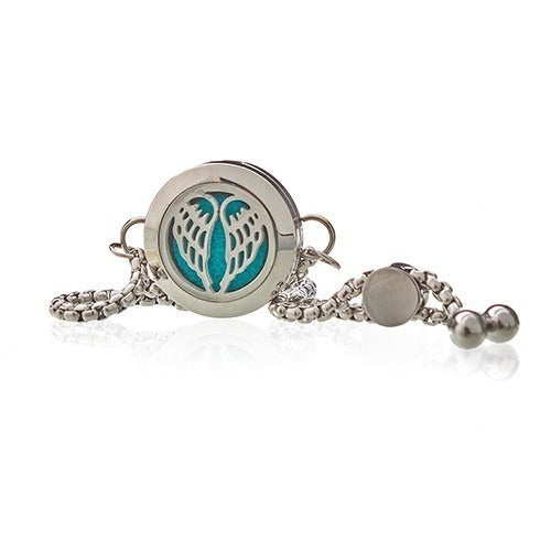A silver necklace with angel wings cutout is presented. The pendant reveals blue felt inside on a white surface.