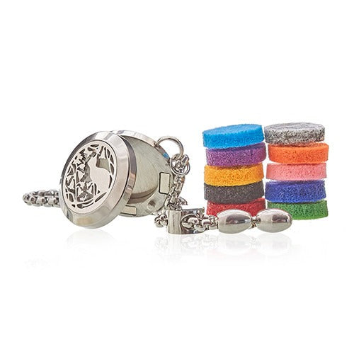 A silver, hinged pendant with a cat design sits open next to two stacks of colorful felt discs, all connected by a silver chain and clasps on a white surface.