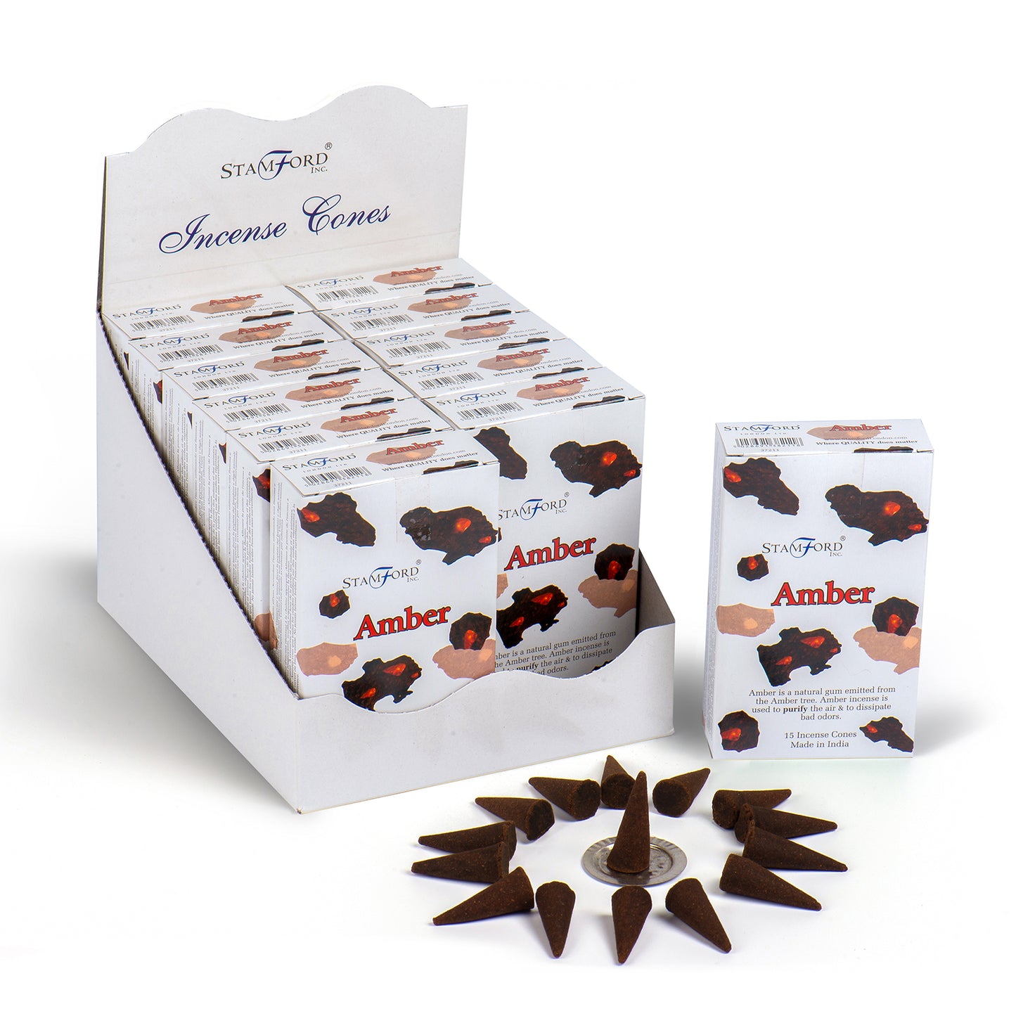 Box of "Stamford Incense Cones" labeled "Amber" displayed in a white carton. Scattered incense cones form a circle on the surface. Text reads: "Amber is a natural gum exuded from various trees." "15 Incense Cones Made in India."