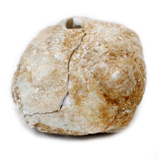 A geode, tan and white, is split with a long vertical crack, revealing its crystal-filled core; it sits on a bright white surface.