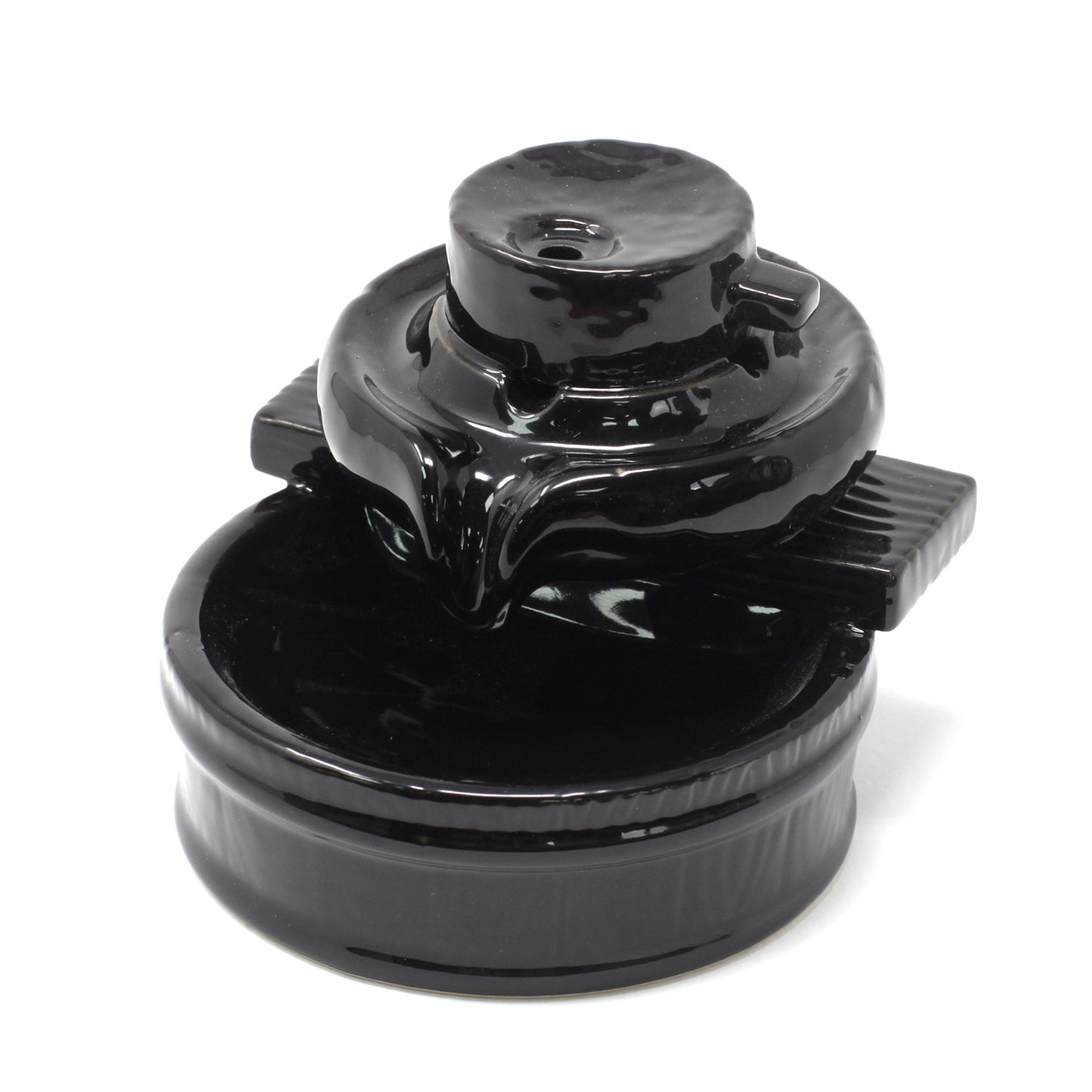 Black ceramic teapot with a round base and a lid, sitting on a circular tray. The teapot features a small spout and handle, all within a plain white backdrop.