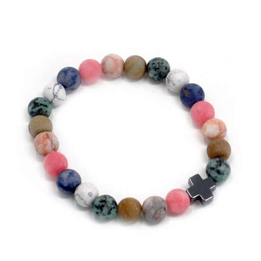 A stretchy bracelet circles, composed of varied matte-finished marble-like beads and one dark metal cross charm. It lies on a plain white background.