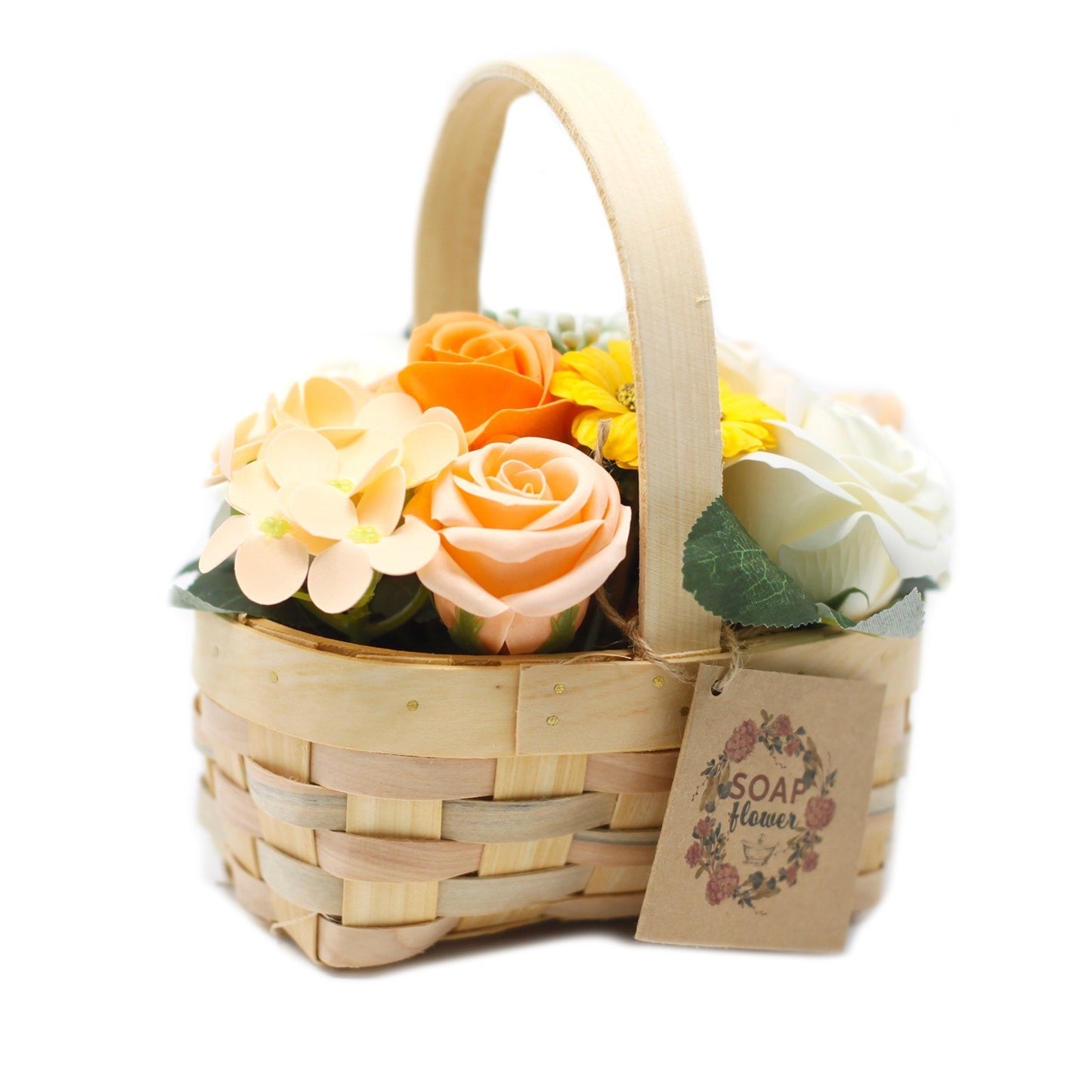 Woven light brown wood basket holds faux flowers. A tag reading "SOAP FLOWER" with a floral wreath, hangs off the side. The context is a stark white backdrop.