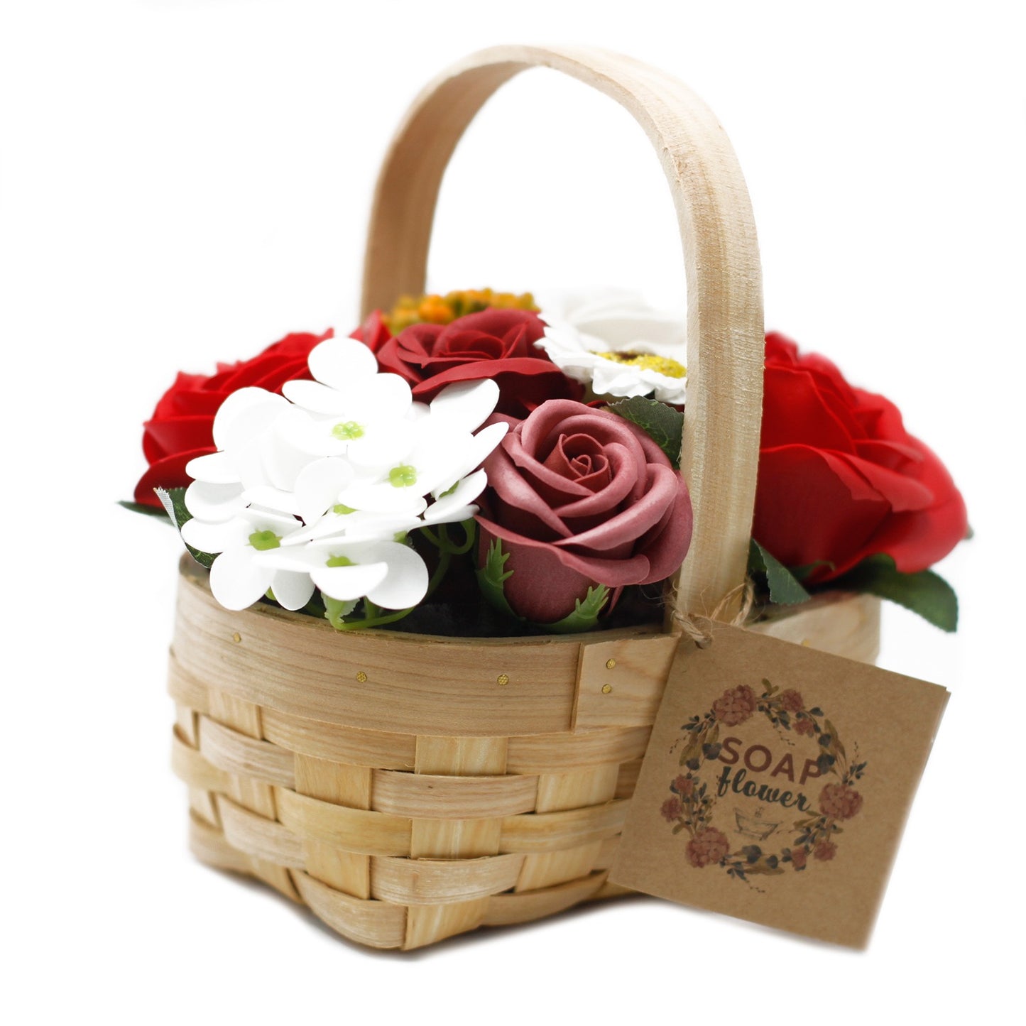 A wooden basket holds an assortment of red, white, and pink soap flowers. A brown tag hangs off the side reading "SOAP flower" in a floral wreath, on a white background.