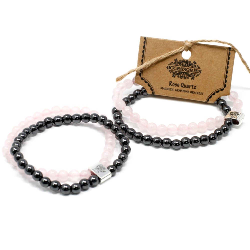 Two beaded bracelets, one with pink beads and one with black beads, are displayed next to a cardboard tag that reads "Accessories Rose Quartz Magnetic Gemstone Bracelet". All on a white surface.