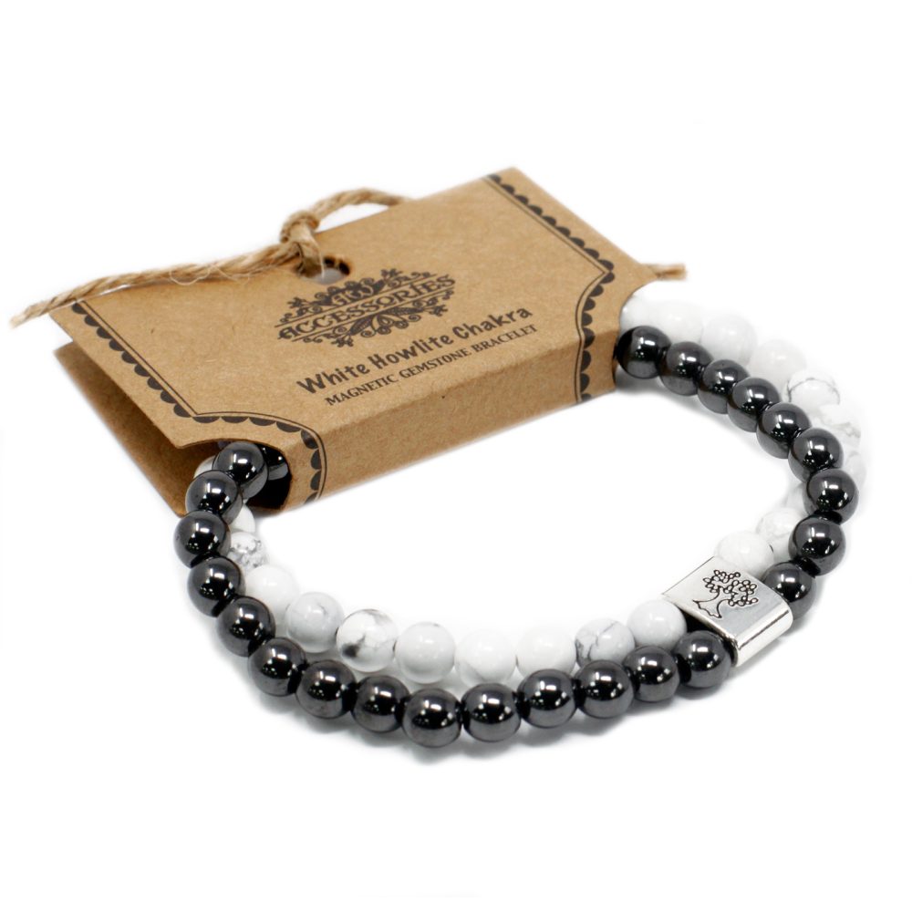 Two beaded bracelets sit near packaging reading "ACCESSORIES" and "White Howlite Chakra, MAGNETIC GEMSTONE BRACELET", all displayed on a white surface. The bracelets are black and white with silver-colored hardware.