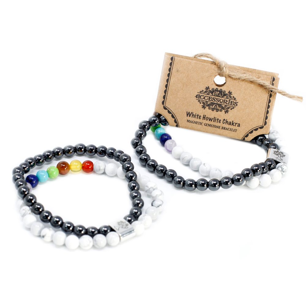 Two beaded bracelets rest beside a brown card on a white surface. The bracelets, "White Howlite Chakra MAGNETIC GEMSTONE BRACELET," feature alternating hematite and white beads and seven chakra-colored beads.