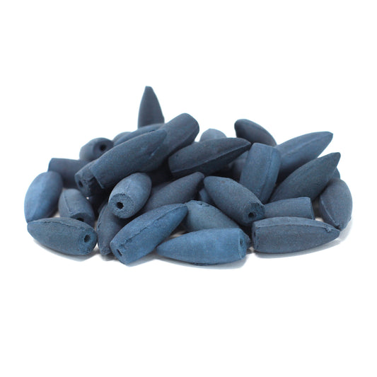 A pile of blue, elongated beads with holes sits against a white background, suggesting they are ready for stringing or crafting purposes.