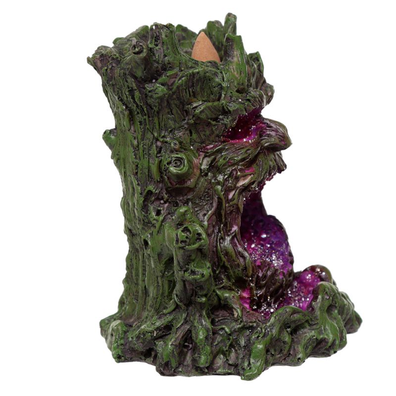 A green, tree-like incense holder with intricate bark details holds an incense cone at the top. A vibrant purple, crystal-like interior suggests a mystical setting within the object.