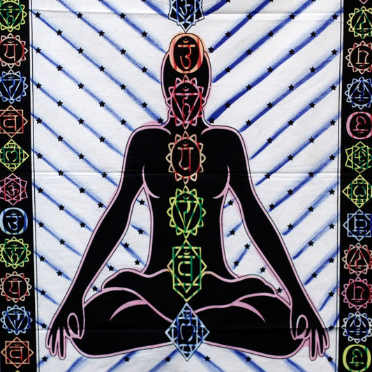 A black figure meditates, displaying seven chakras with Sanskrit symbols, on a white background with blue diagonal lines and stars.