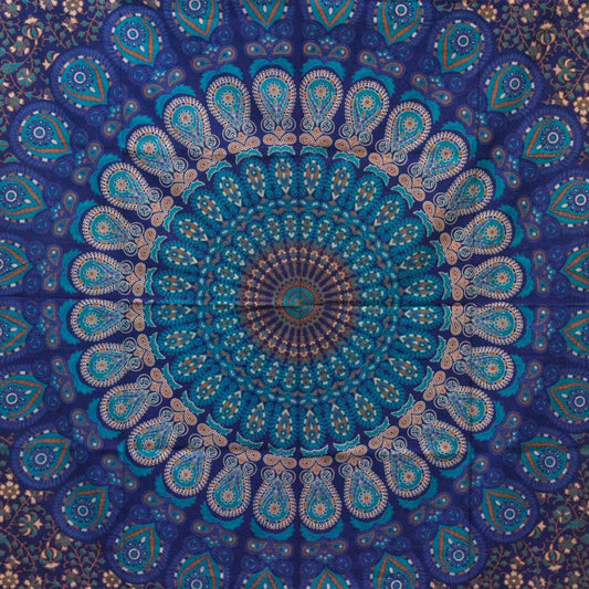 A mandala tapestry displays a circular pattern of teal, blue, and brown paisley designs. The central design radiates outwards. The context is an overhead view of the textile.