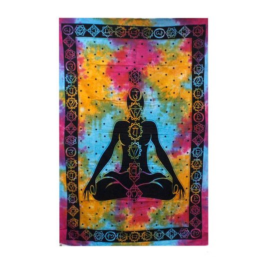 A tie-dye tapestry displays a meditating figure with chakra symbols; the figure is black, set against a multicolored, starry background.