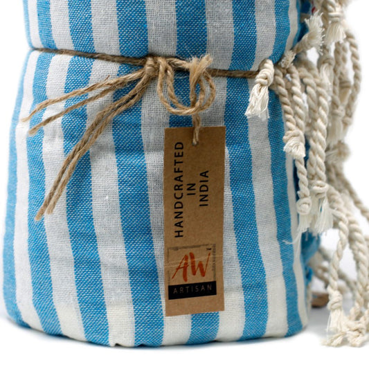 A blue and white striped towel is tied with twine. A tag reads, "HANDCRAFTED IN INDIA" and "AW ARTISAN". The towel is presented on a white background.