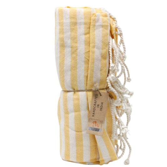 A yellow and white striped towel is rolled and tied with twine. A tag reading "HANDCRAFTED IN INDIA" is attached.