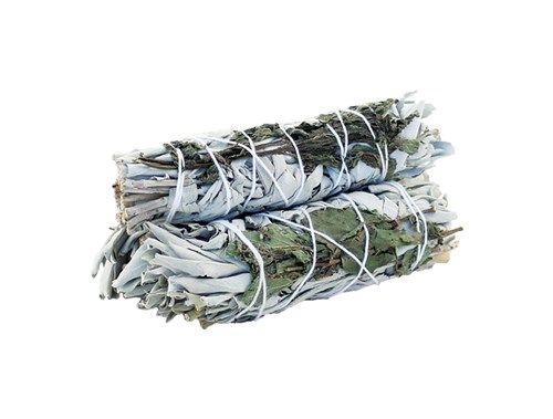 Two sage bundles, secured with white string, are stacked on top of each other in a white space.