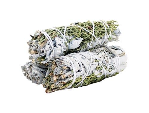 Two bundles of sage and greenery, bound with white string, are stacked on top of each other against a white background.