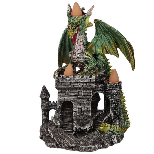 A green dragon figurine rests on a stone castle incense holder. It holds cones on its head and castle towers, all set on a rocky surface.