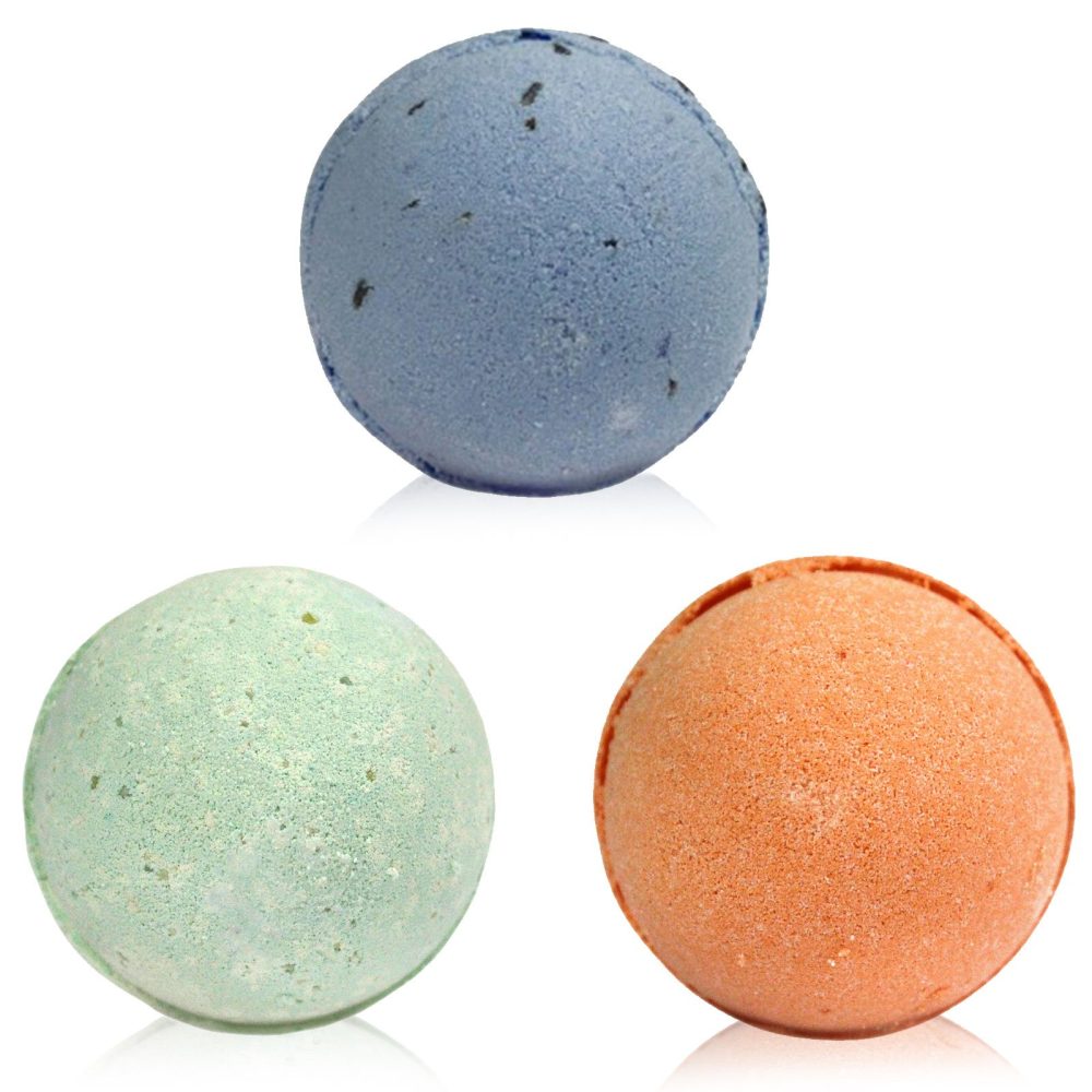 Three bath bombs, in light blue, light green, and light orange, sit on a white background.