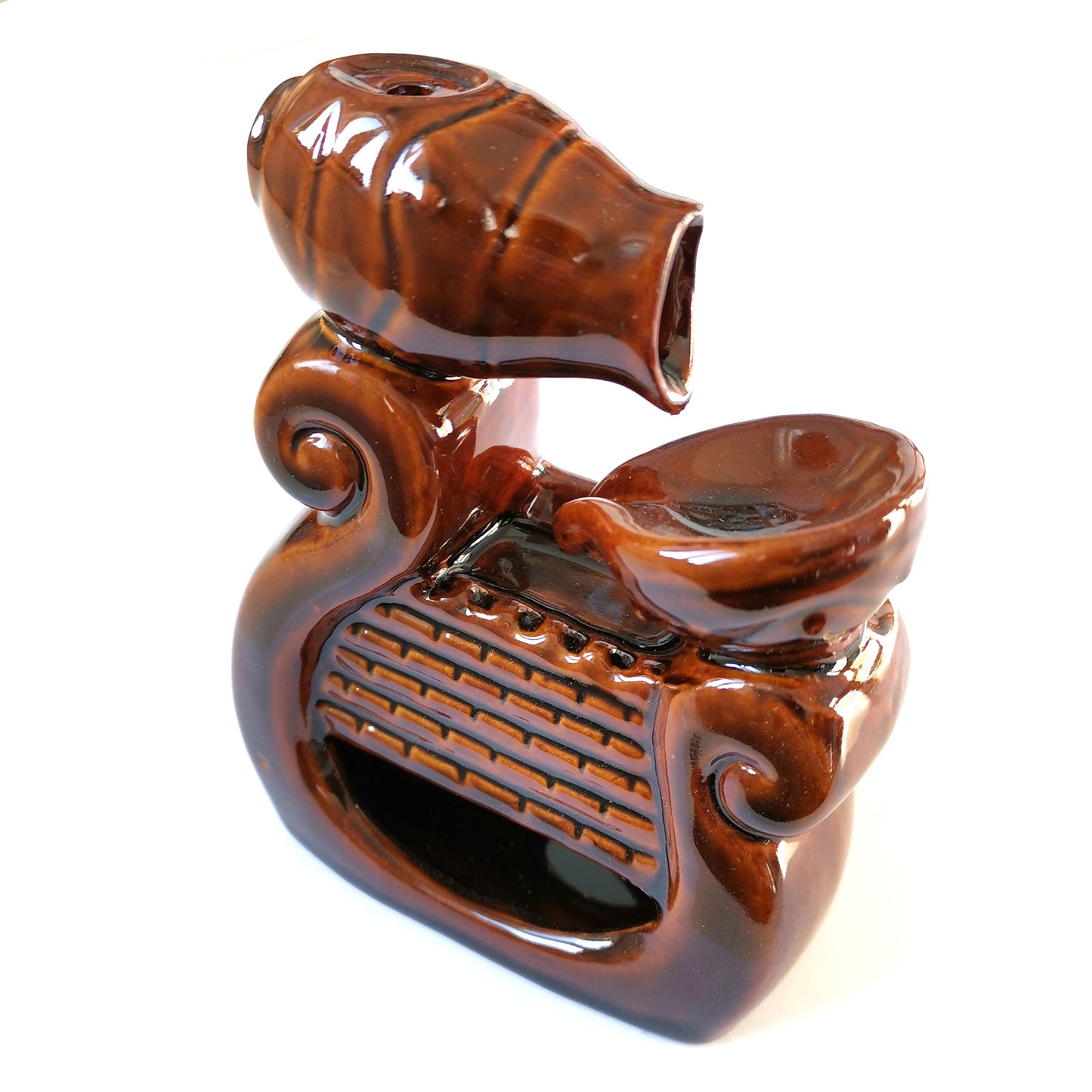 A glossy, brown ceramic incense holder with a swirling design features a small bowl and angled vase, set on a flat surface, evoking an ornate, decorative style.