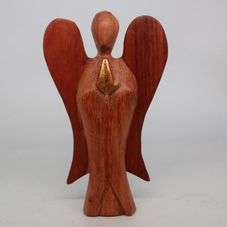 A wooden, reddish-brown angel figure stands with folded hands. A golden detail is added on the chest against a white background.