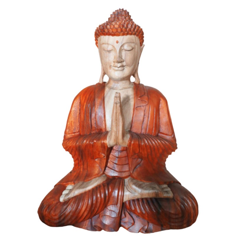A wooden Buddha statue sits in a meditative posture, hands in a prayer position, with a serene expression and traditional robe, against a neutral white background.