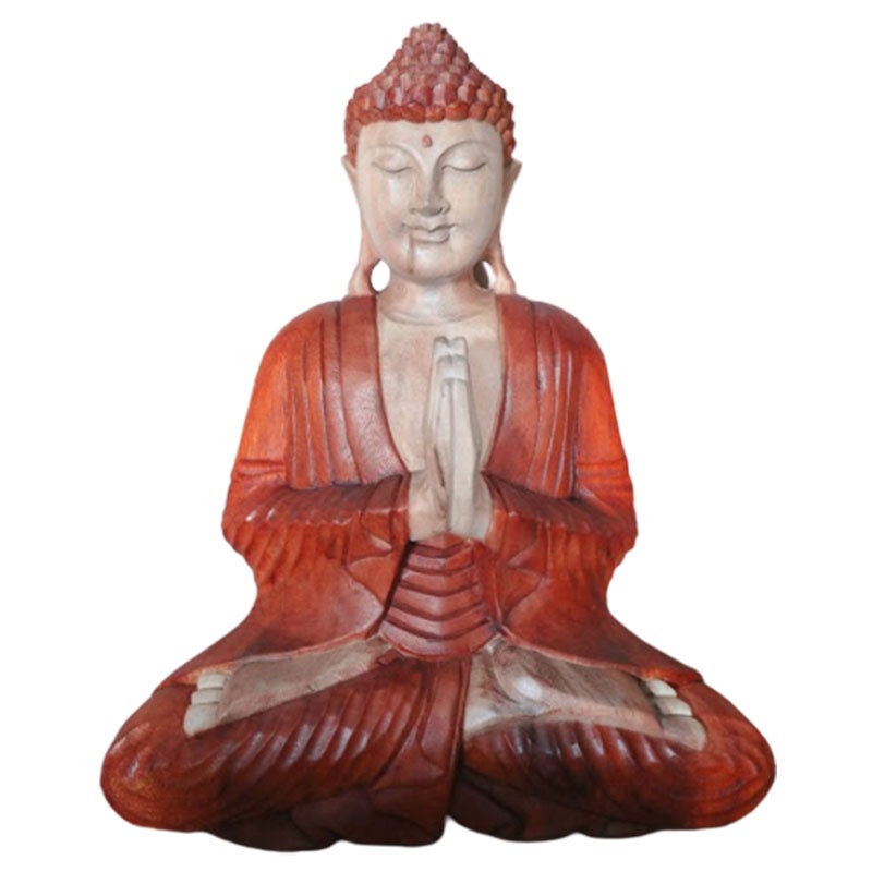 A wooden Buddha statue sits cross-legged with hands together in prayer, displaying a peaceful expression. The statue features intricate carvings and reddish-brown coloring, isolated on a plain background.