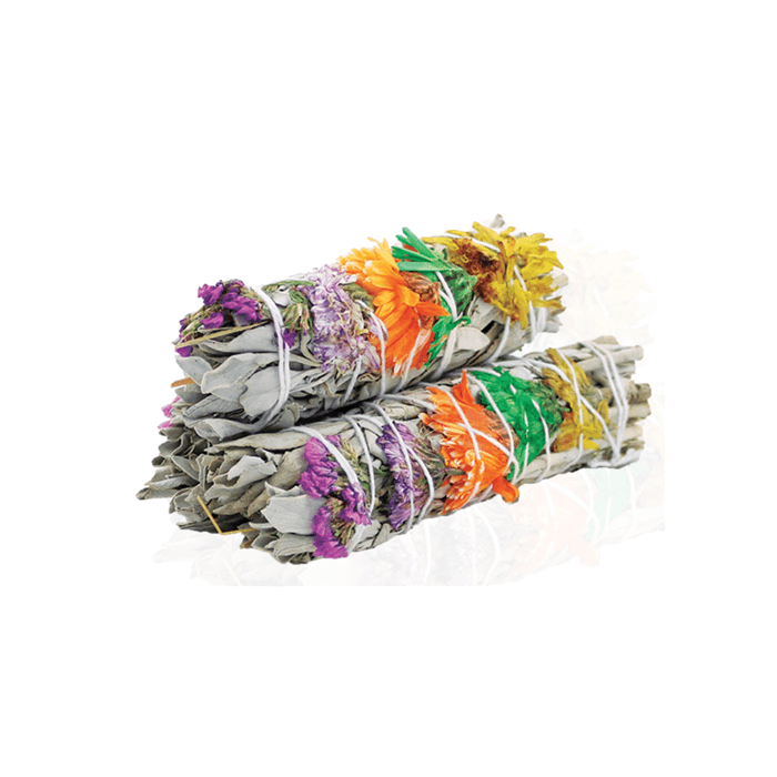 Two bundles of dried white sage, wrapped with white string, rest on a white surface. Colorful dried flowers adorn the top of each bundle.