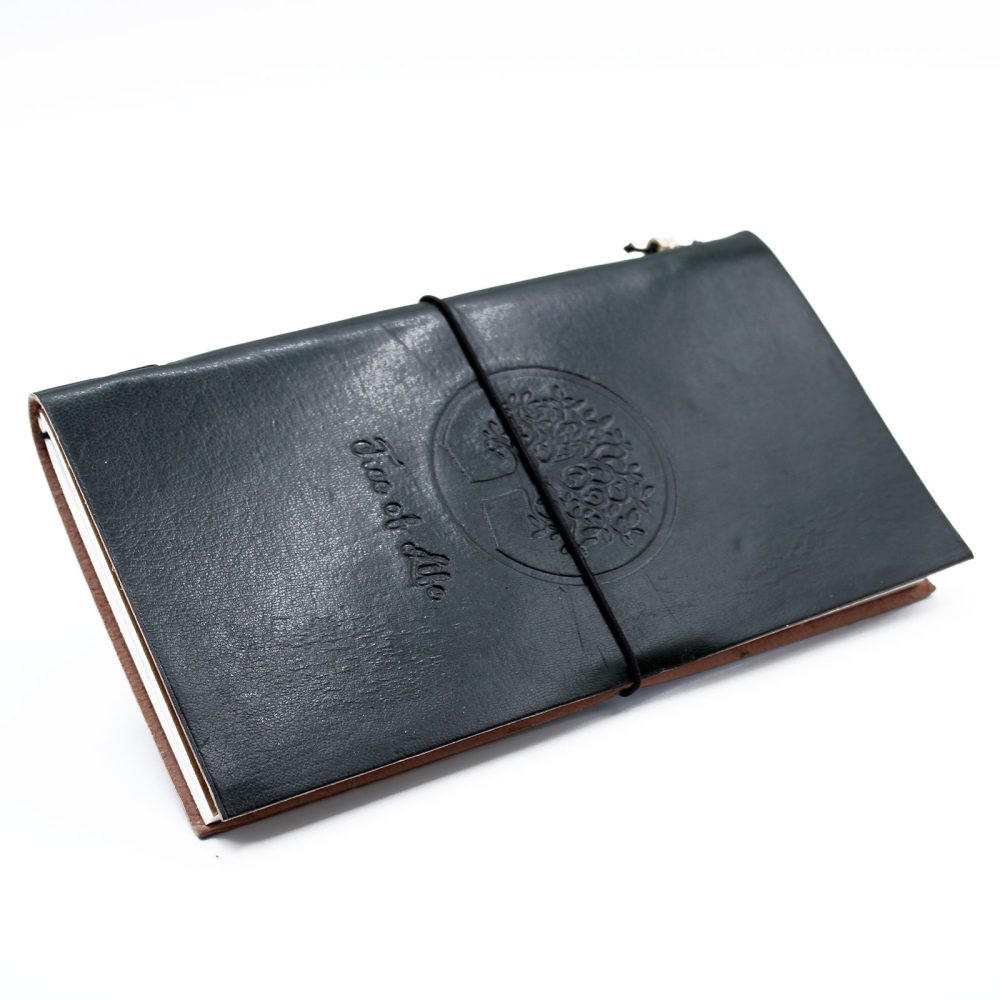 A dark green, leather-bound journal is closed with a black elastic band. Embossed on the cover is a design of a tree, and the words "Tree of Life." The background is white.