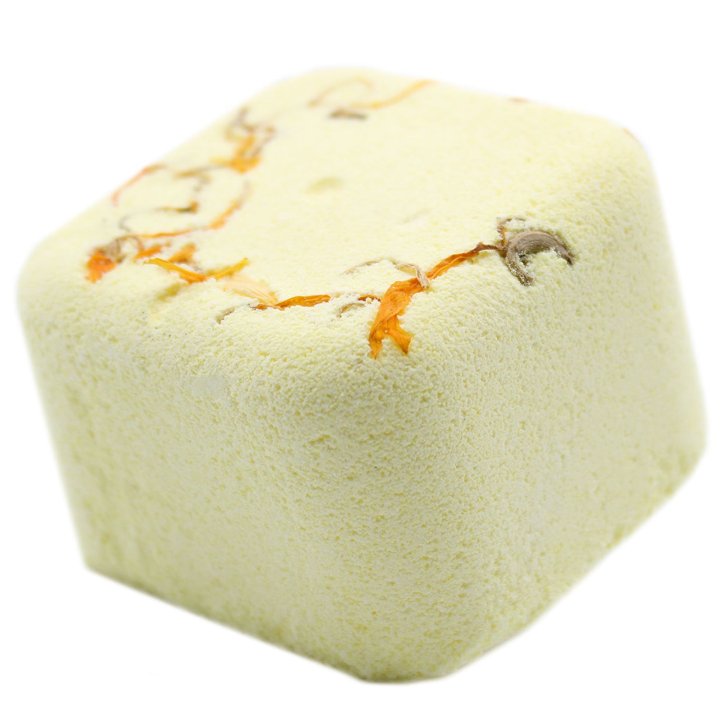 A cube-shaped, pale yellow bath bomb features small orange and brown flower petals embedded on its surface, set against a plain white background.
