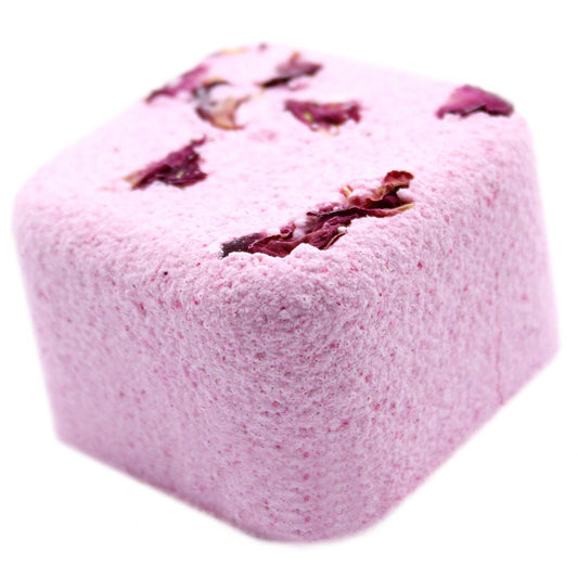 A pink bath bomb, studded with dried rose petals, rests on a white background.