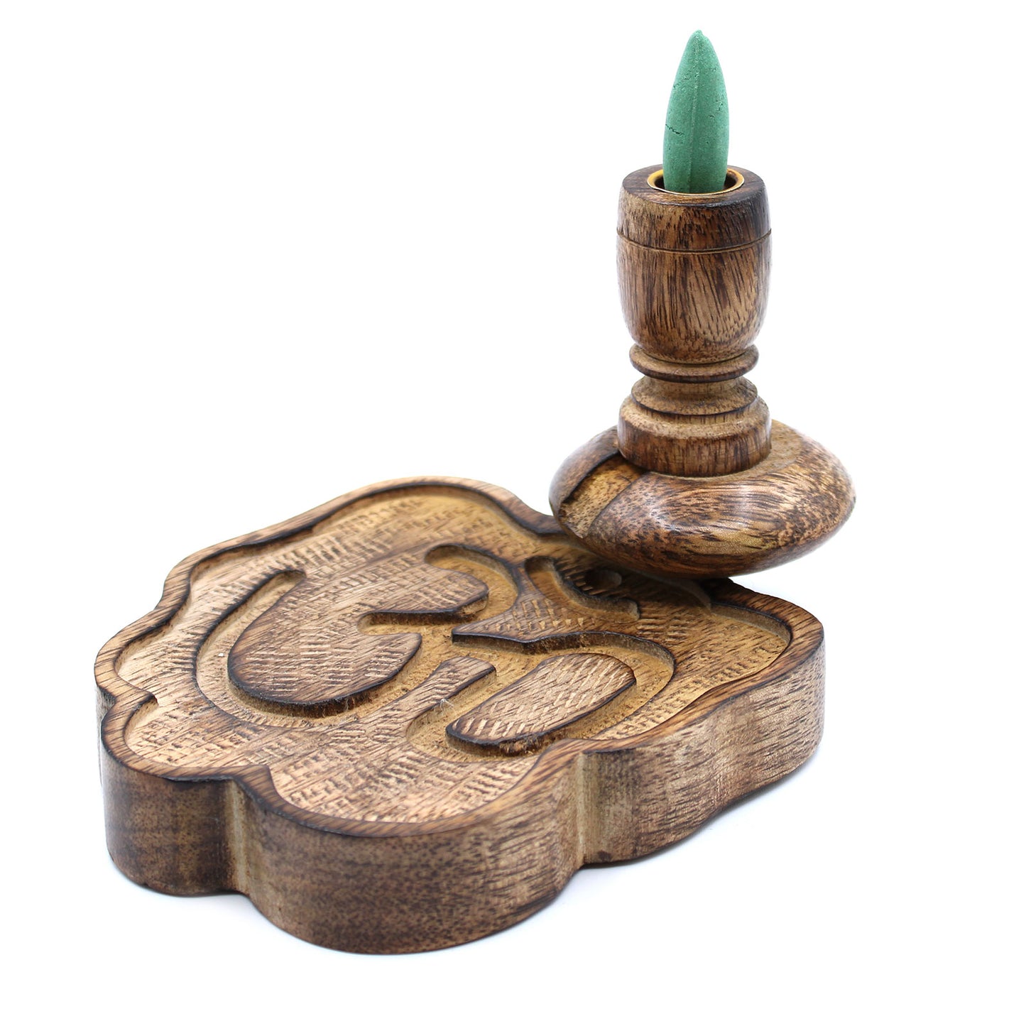 A carved wooden incense holder features an upright green cone. The base is intricately shaped and embossed with the "Om" symbol, set against a plain white background.
